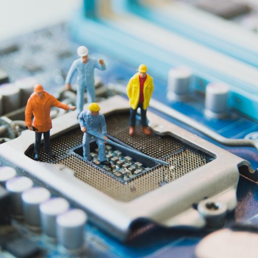 Four model crewmen working on a CPU port on a motherboard